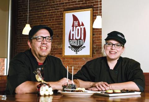 Brandon and Wendy Buckner, founders of The Hot Chocolatier sit at a table with some of their treats