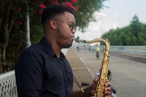 Local artist Joshua Allen plays saxaphone on Walnut St bridge
