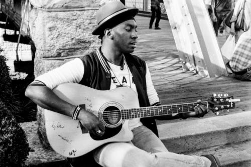 Local artists Luke Simmons plays guitar on Walnut St bridge