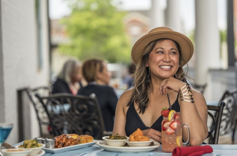 Woman eats at Davis Wayne's on the patio