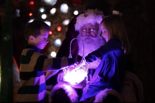 santa with kids looking in a lit up basket