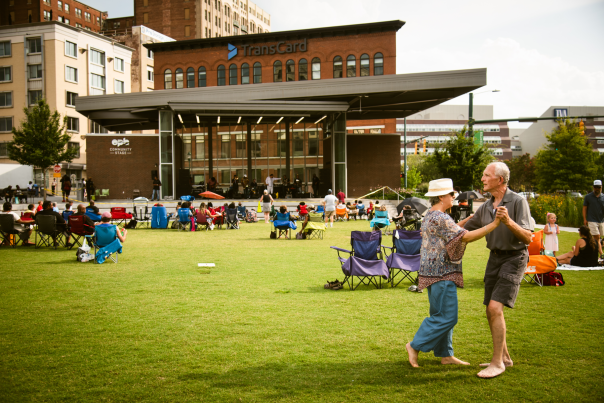 couple dances barefoot in the grass during a soul sundays in the park concert at miller park